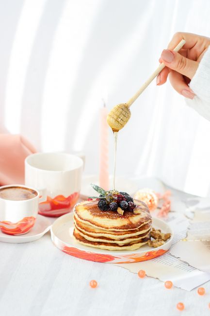 Stack of pancakes topped with berries and syrup, perfect breakfast scene.