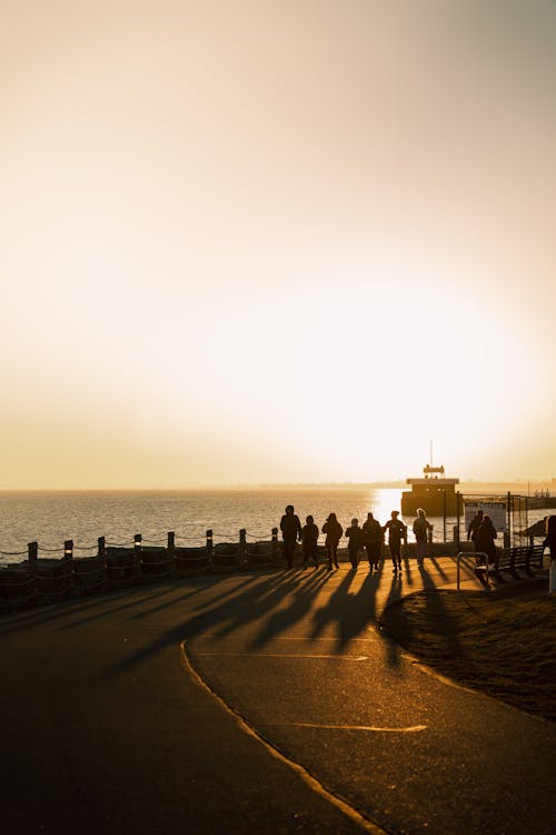 Silhouette of People Walking on Promenade at Dusk