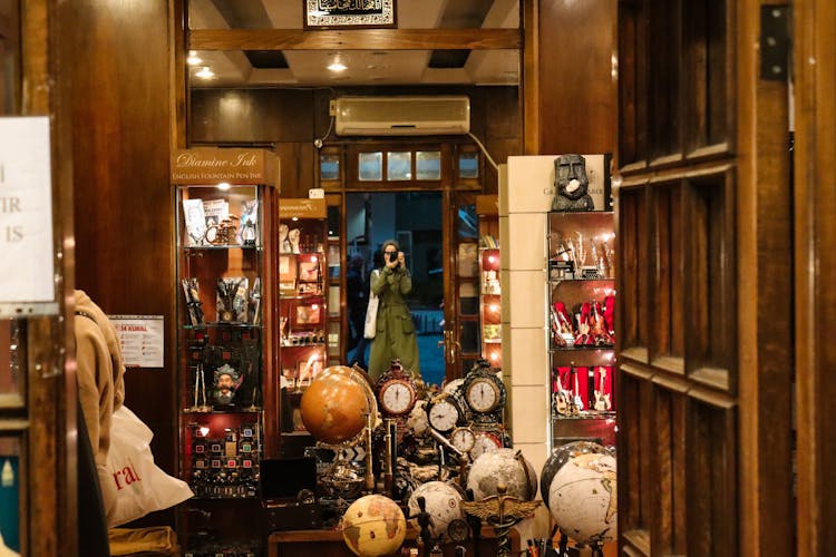 Woman Taking Pictures In Store Doorway