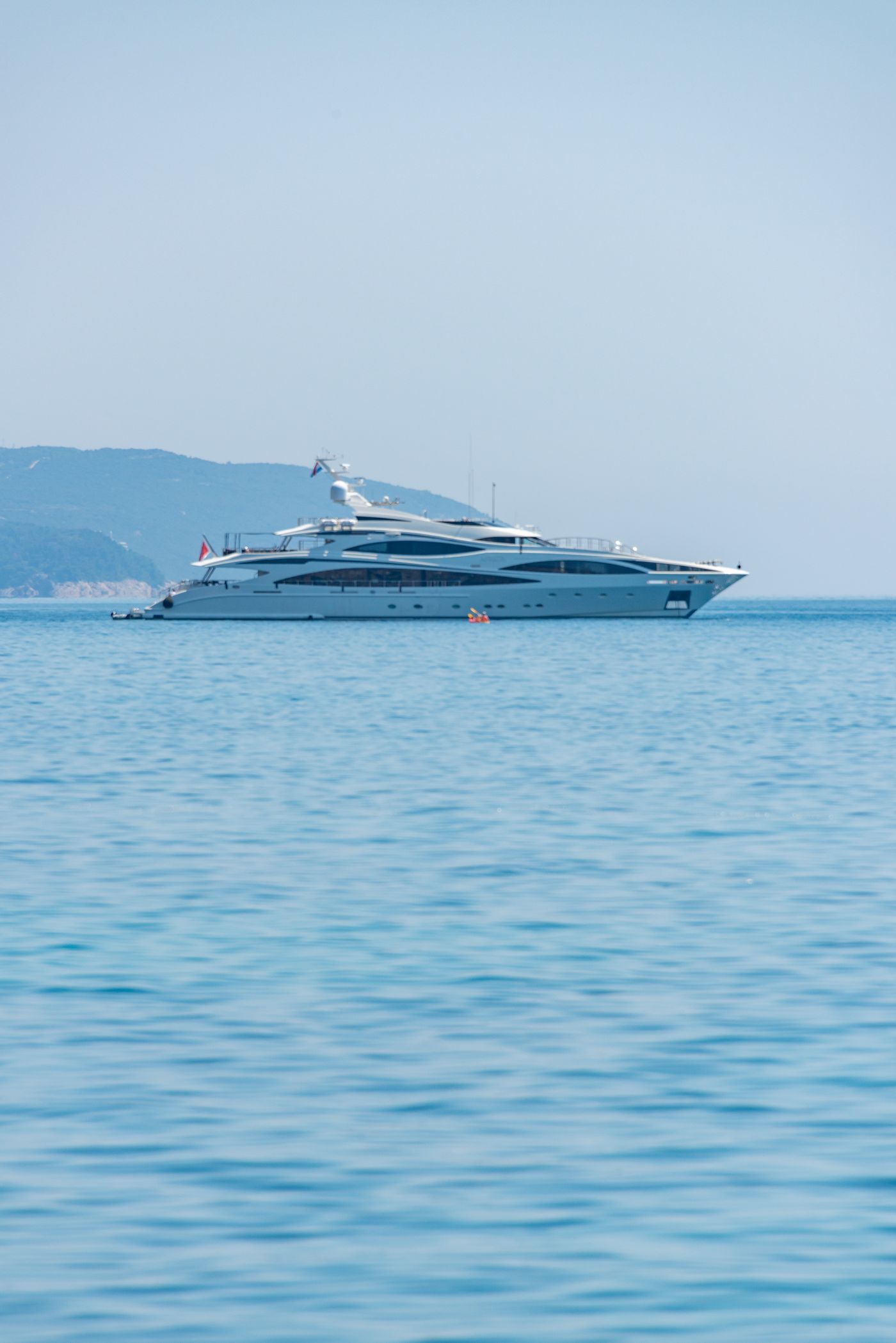 White 53-metre superyacht lying at anchor in calm water