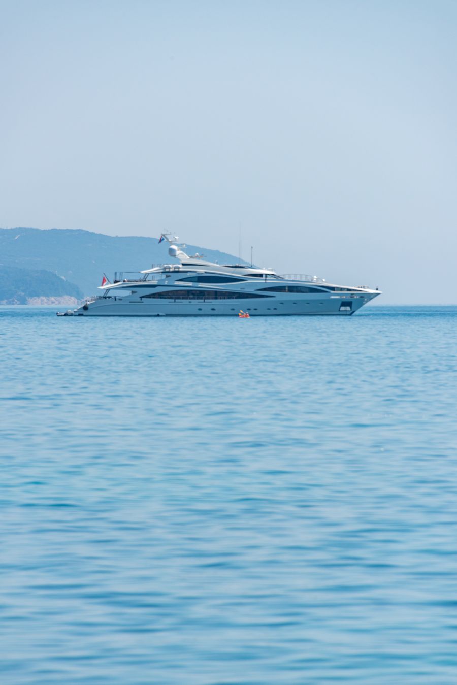 White 53-metre superyacht lying at anchor in calm water