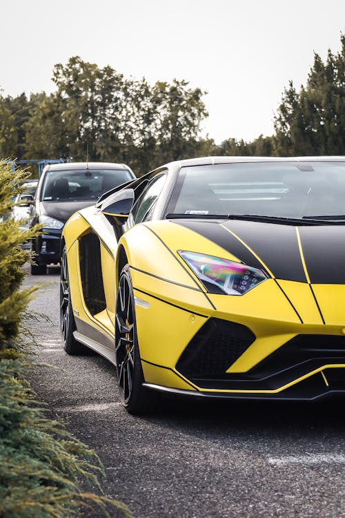 View of a Black and Yellow Lamborghini Aventador on a Street 