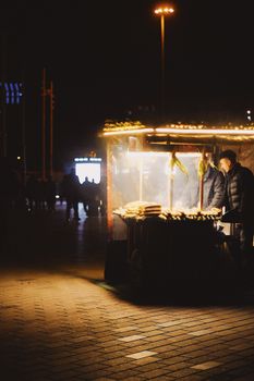 A bustling street food stall illuminated at night in Istanbul, Turkey, showcasing local culinary life.