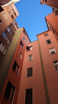 Low-angle view of colorful urban buildings contrasted against a clear blue sky.