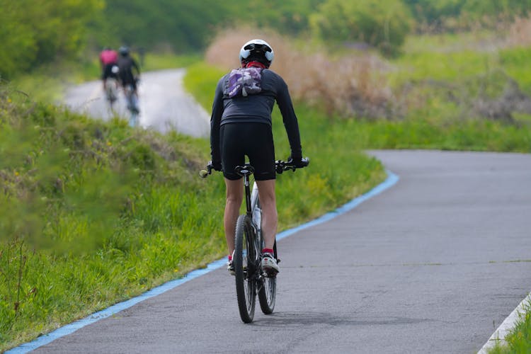 Man Riding Bike On Road In Countryside