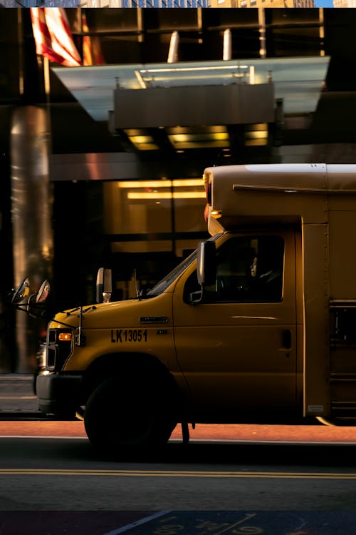 View of a Yellow Truck Driving on a Street in City 