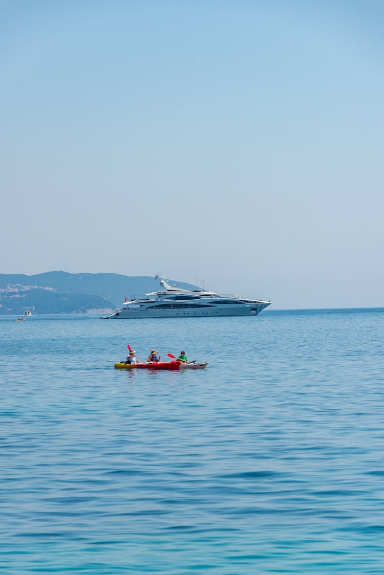 Kayak And A Yacht On The Sea