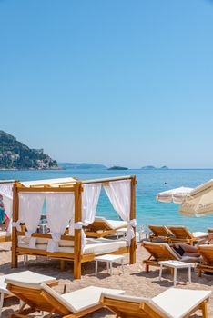Scenic beachside view with sunbeds, canopy, and clear blue sea, ideal for vacations.