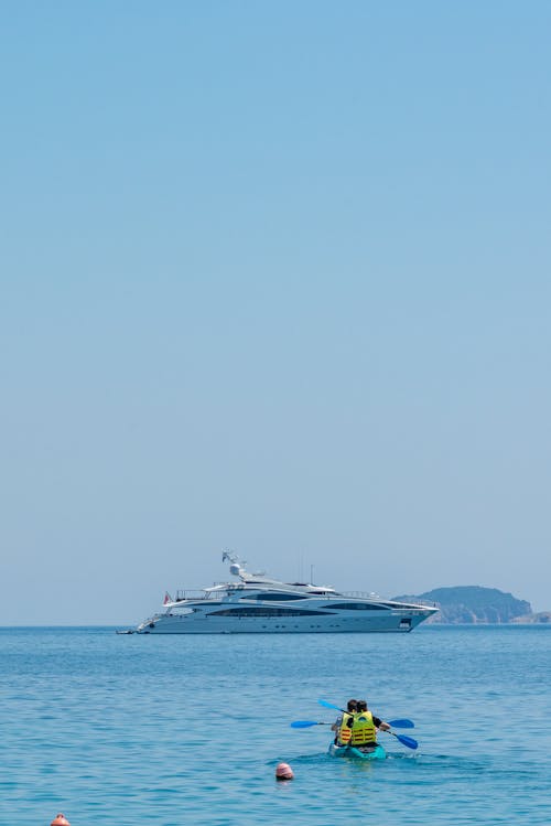 People Boating with Motor Yacht behind