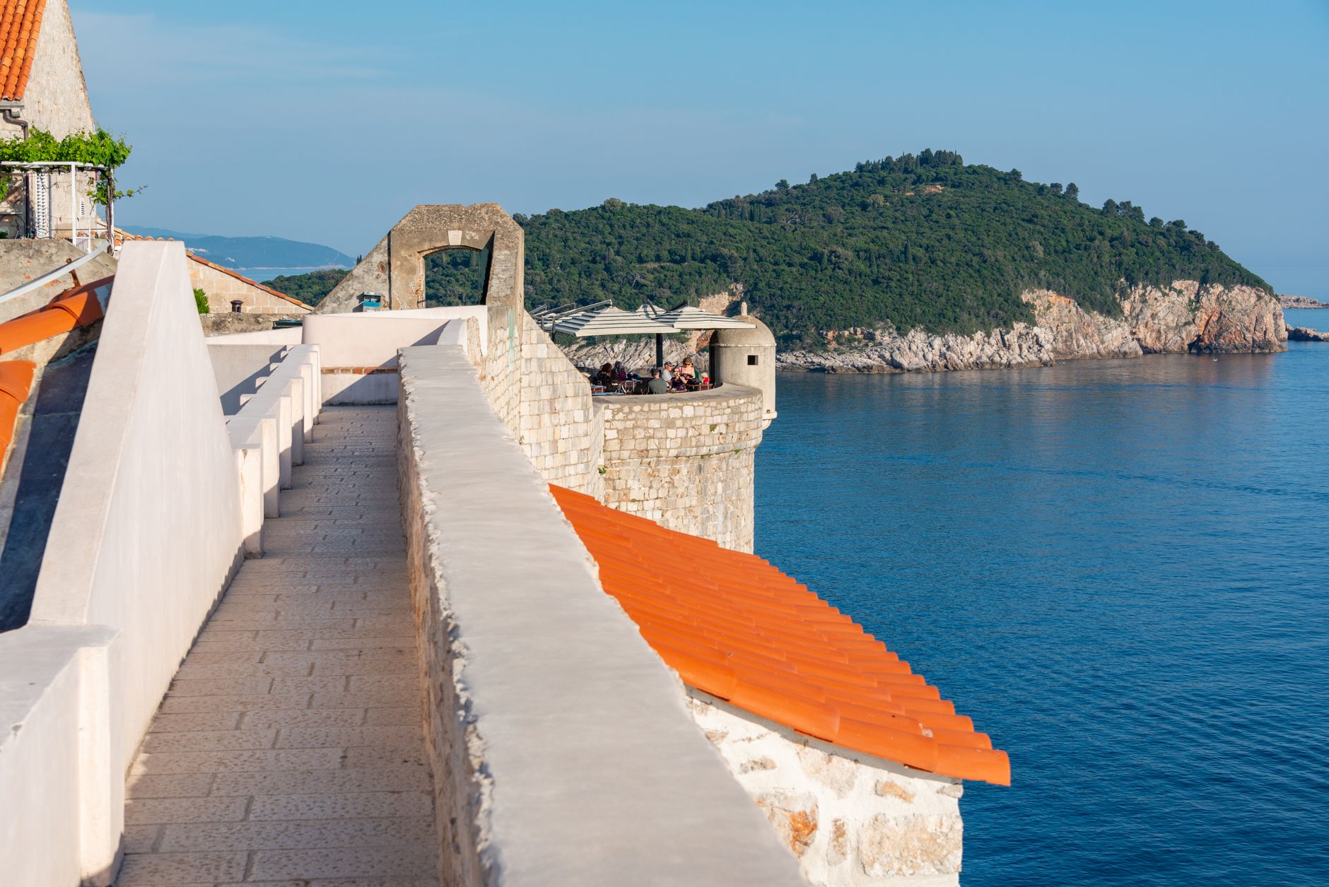 Quiet Dubrovnik side street in early morning, locals passing
