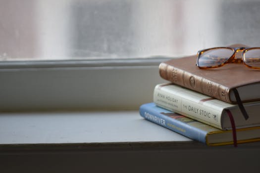 A serene stack of books with glasses on a windowsill in Memphis, Tennessee.