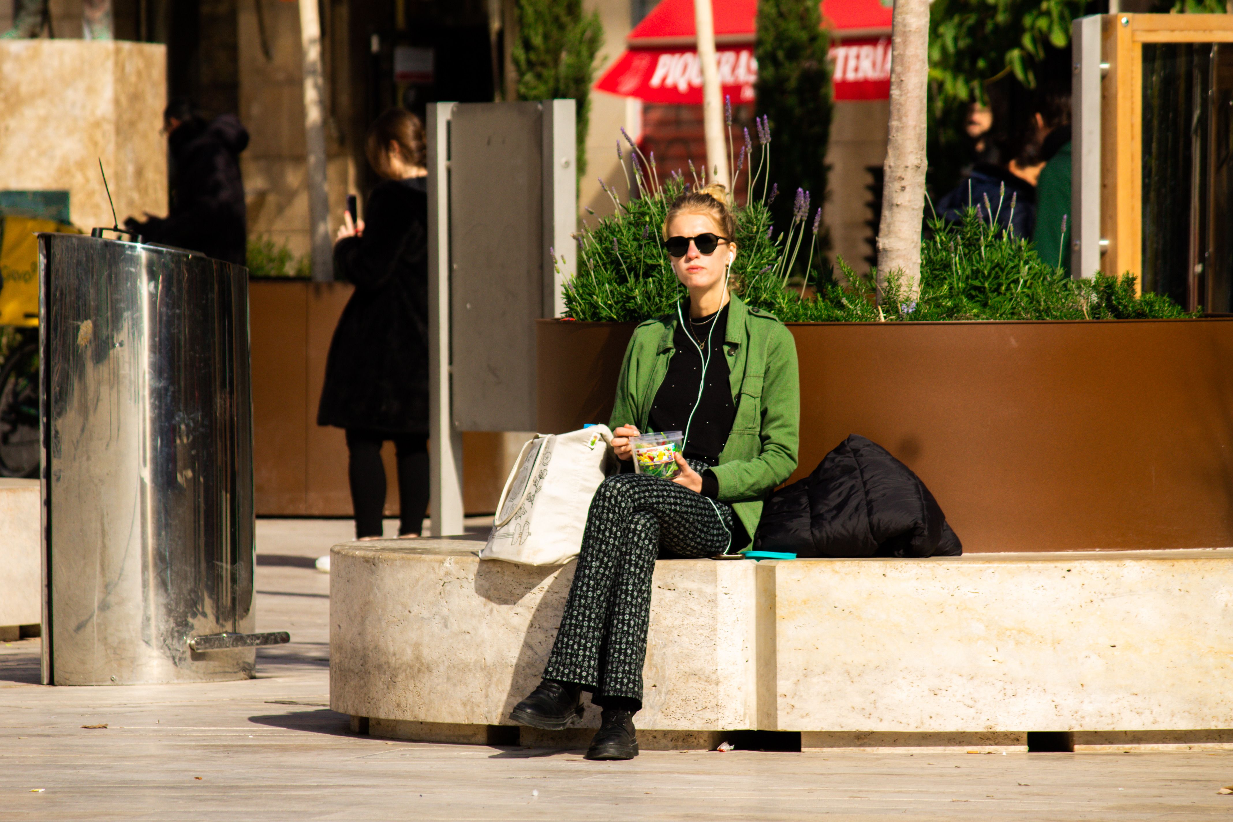 A woman enjoys a peaceful break on a sunny day in Valencia, Spain, surrounded by urban settings.