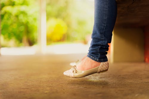 Person Wearing Beige Flats While Sitting on Bench