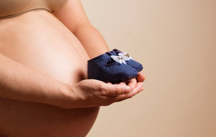 Woman Holding Pair Of Toddler Blue Shoes