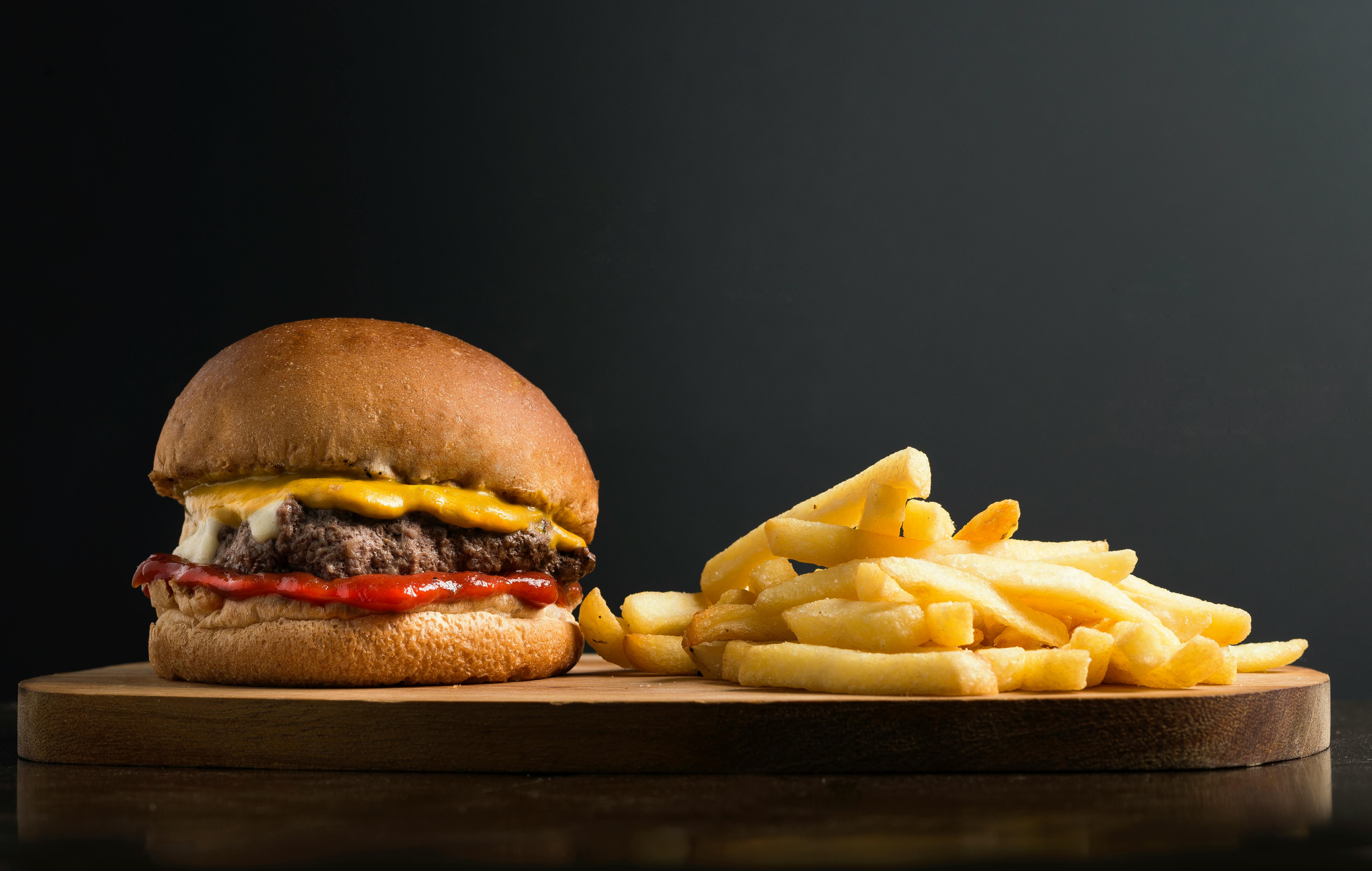 classic hamburger and french fries on wooden board