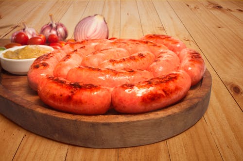 Sausages on Top of Brown Wooden Board