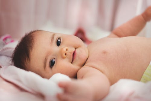 Free Baby Liggend Op Roze Bed Stock Photo