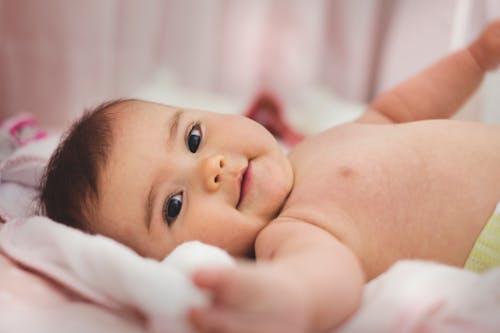 Bambino Sdraiato Sul Letto Rosa