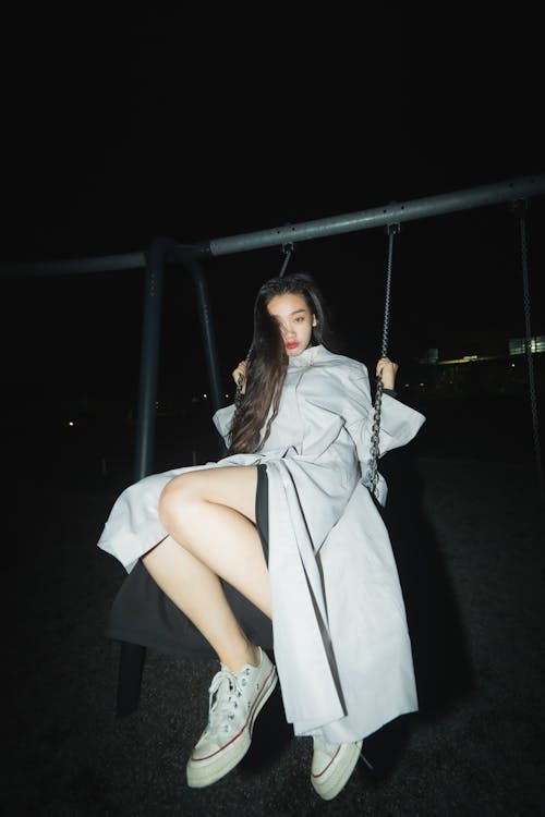 Free Woman Wearing a Coat on a Swing  Stock Photo