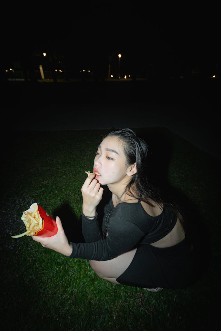 Photo Of A Woman Eating In A Park 