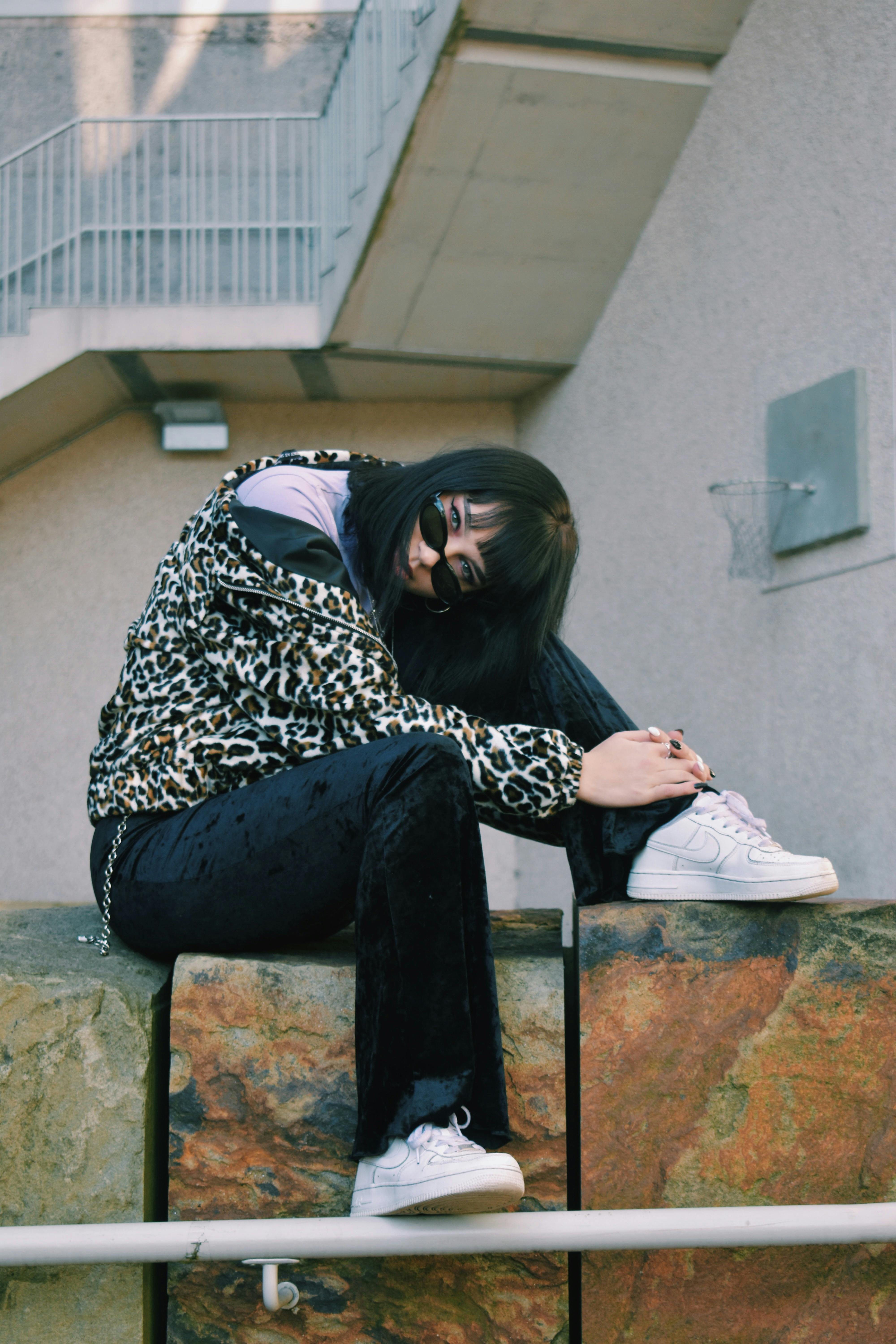 布里斯托尔的时尚女性戴着太阳镜，身着动物印花时装，在户外摆姿势