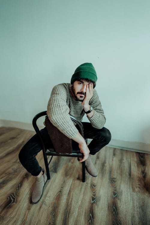 Free Man Wearing Sweater Posing on a Chair  Stock Photo