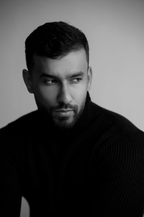 Free Black and white portrait of a young man in a turtleneck looking away, with a minimalist style. Stock Photo