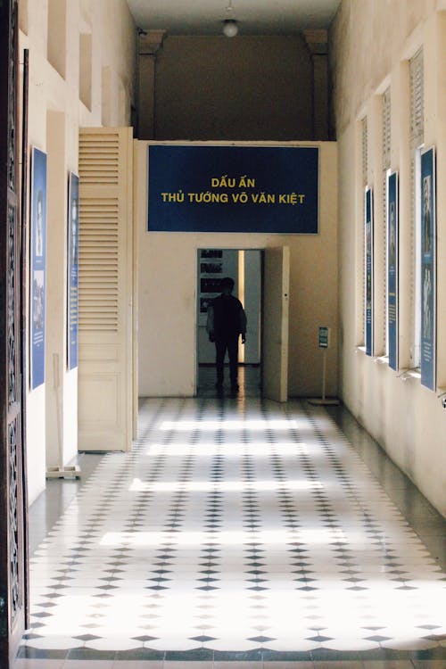 Person Standing in Darkness behind Corridor