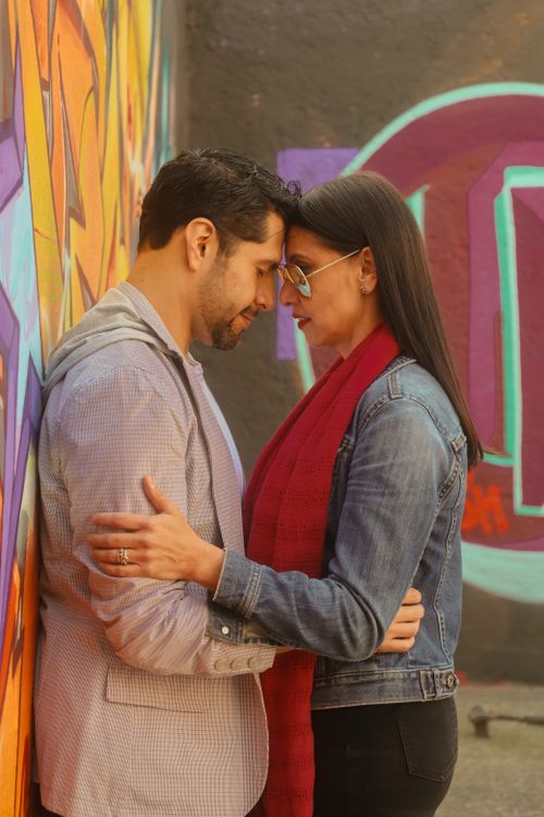 Free Couple embracing by a vibrant graffiti wall, sharing a heartfelt connection. Stock Photo