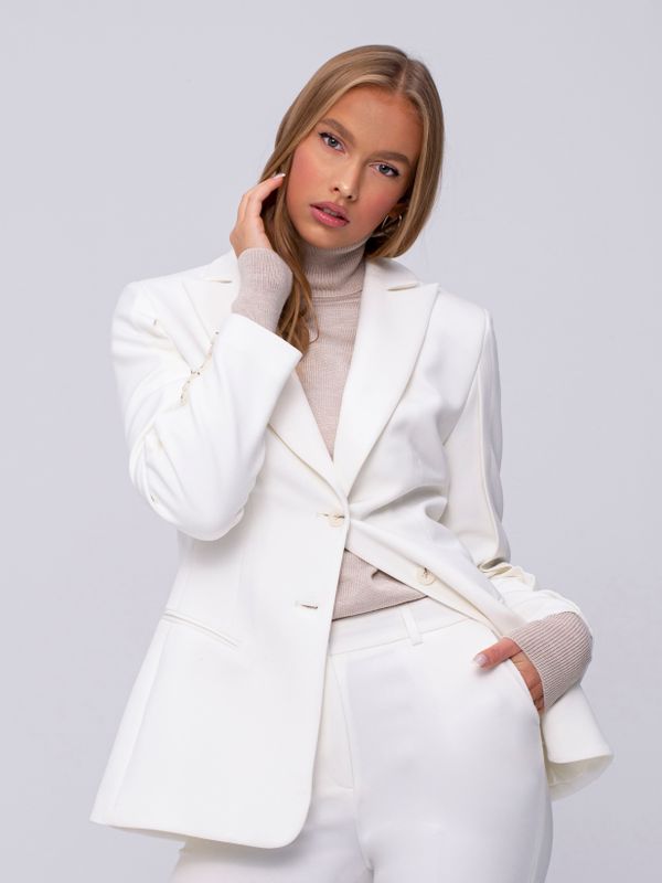 Woman in brocade blazer and tailored trousers