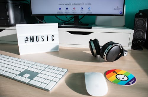 Free Computer and Headphones on the Desk with Hashtag Saying Music  Stock Photo