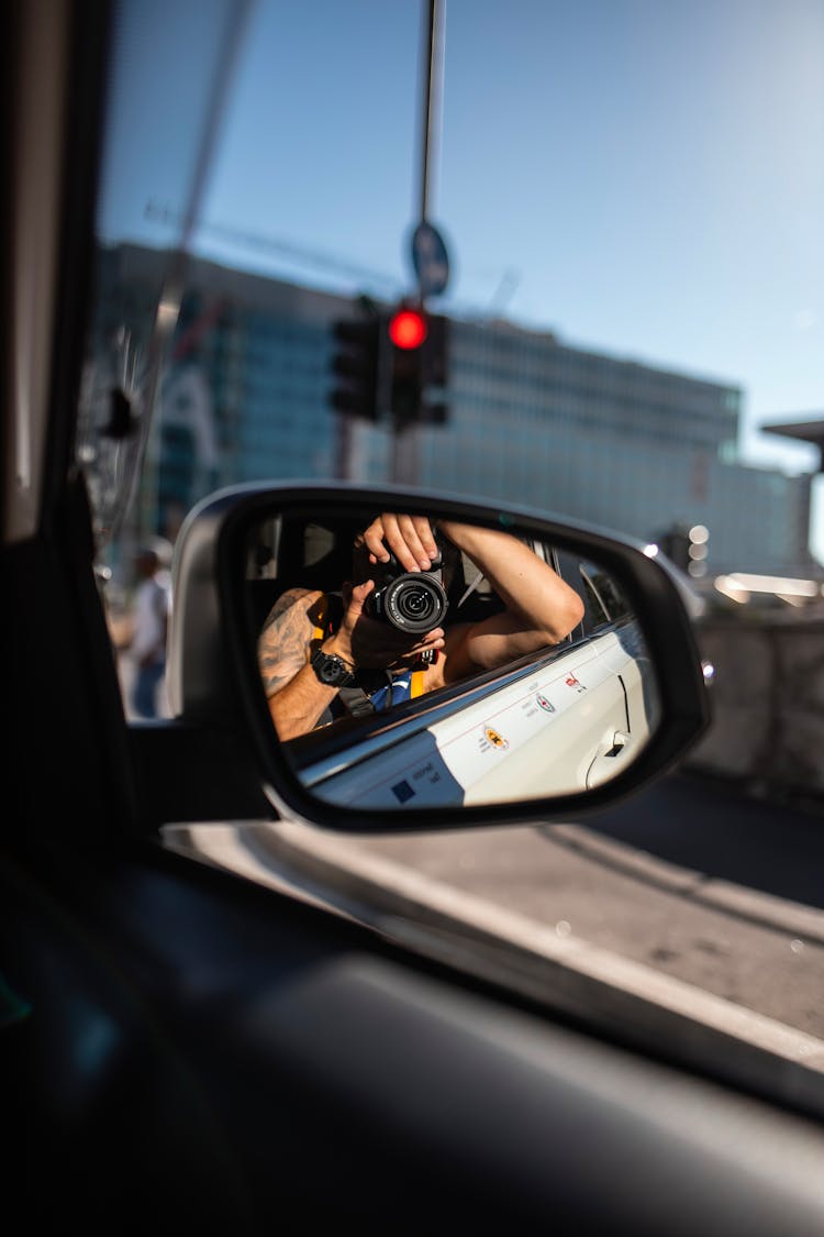 Man Taking Photos In Car Mirror