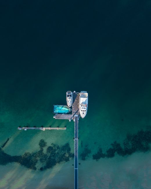Aerial photography capturing moored boats and clear waters at a Sydney dock.