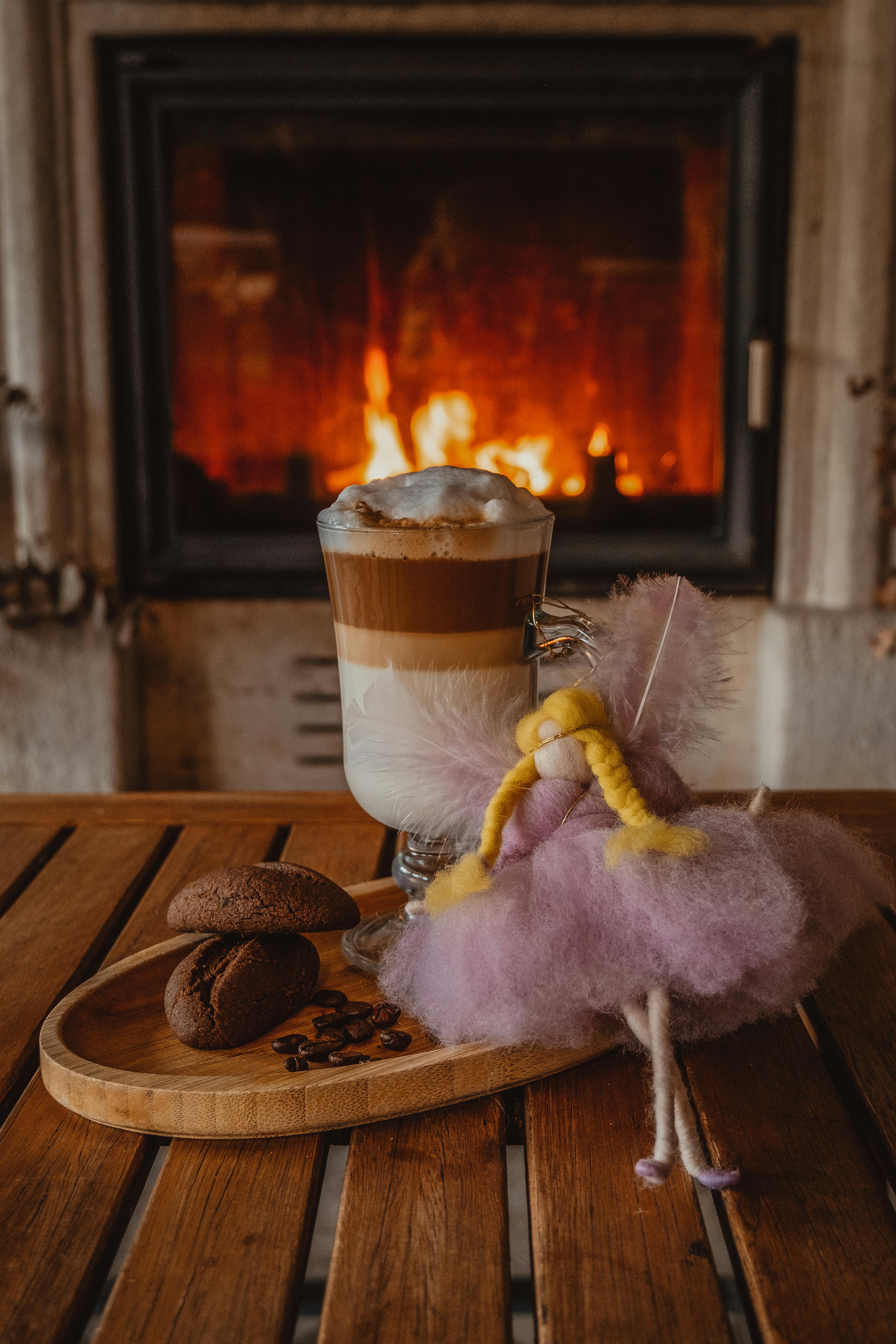 coffee in glass and doll on wooden board