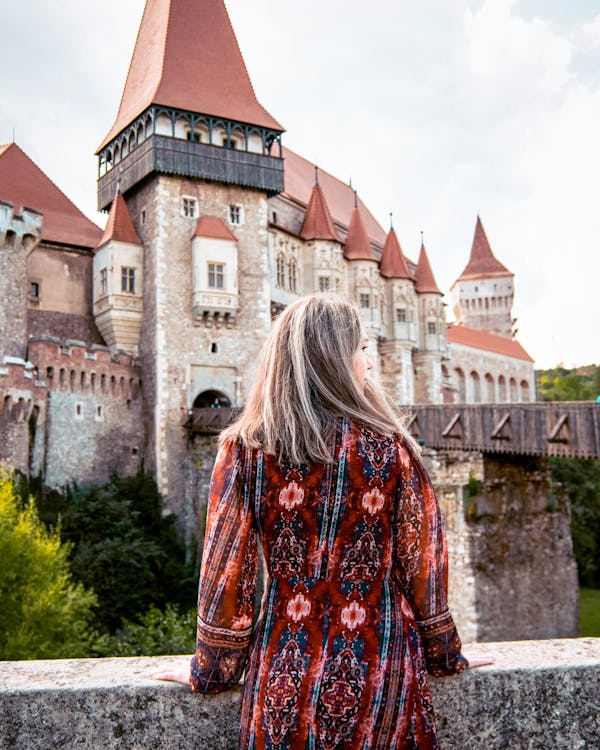 Woman Standing in front of Corvin Castle in Transylvania, Romania