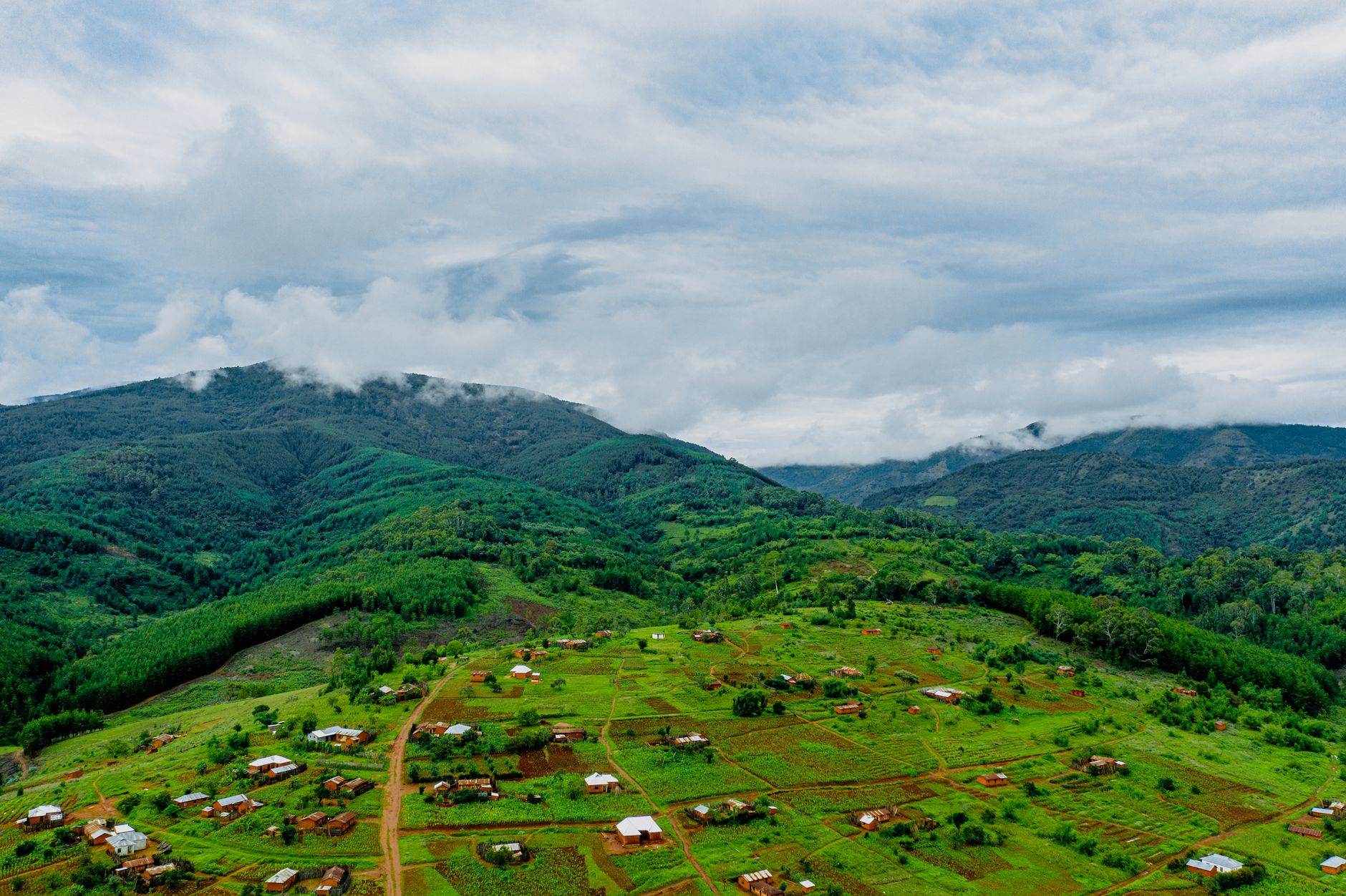 Aerial shot of Makete village in Tanzania, showcasing lush green landscapes and rolling hills.