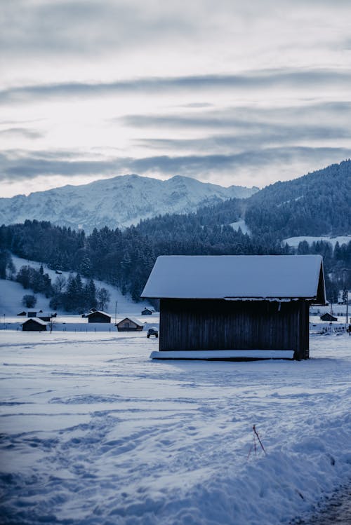 Farmhouse and Scenic Mountains in Winter 