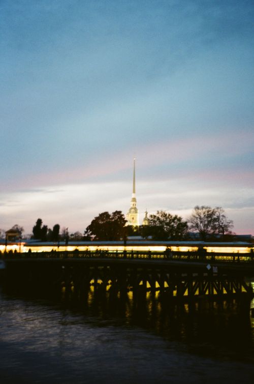Free A serene twilight view of the Peter and Paul Fortress, reflecting on the river with a beautiful sky backdrop. Stock Photo