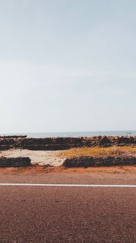 A scenic coastal road near the ocean in Rameswaram, India, showcasing natural beauty.
