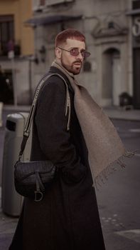 Man with a trendy winter outfit in Madrid's urban setting, showcasing elegant style.