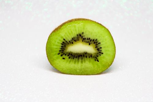 Free Close-up of a juicy kiwi slice showcasing its vibrant green color and unique texture. Stock Photo