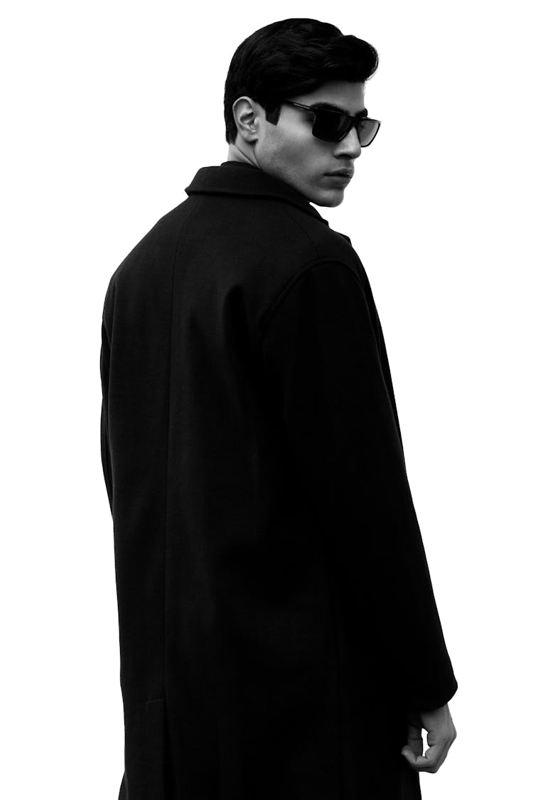 Man In Black Coat And Shades Look Over Shoulder