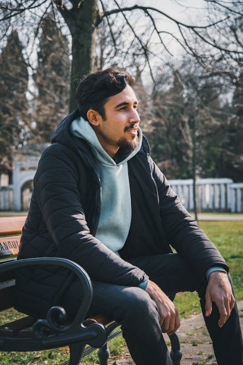 Man Sitting on a Bench in a Park 