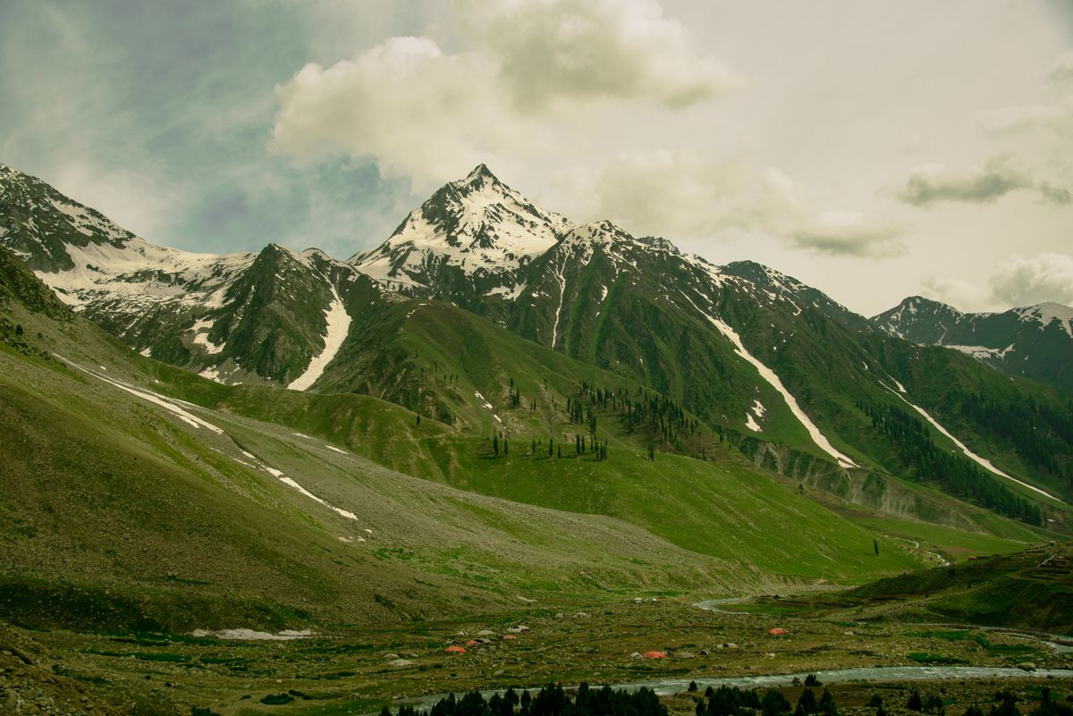 A green mountain landscape with meadows and blue sky