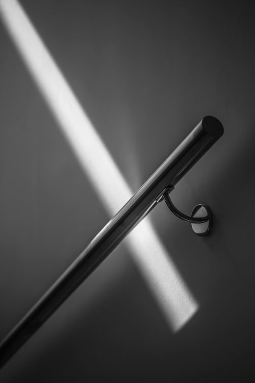 Free Stainless steel handrail casting shadows in a minimalist black and white style. Stock Photo