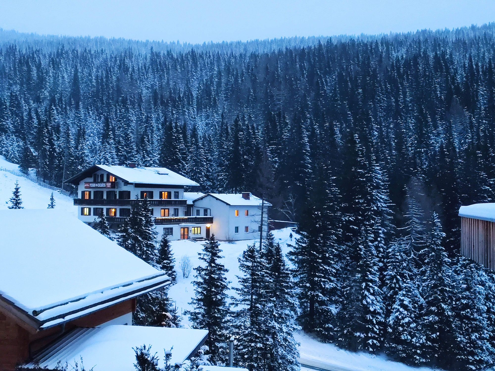Charming mountain resort surrounded by snowy coniferous forest in Styria, Austria during winter.