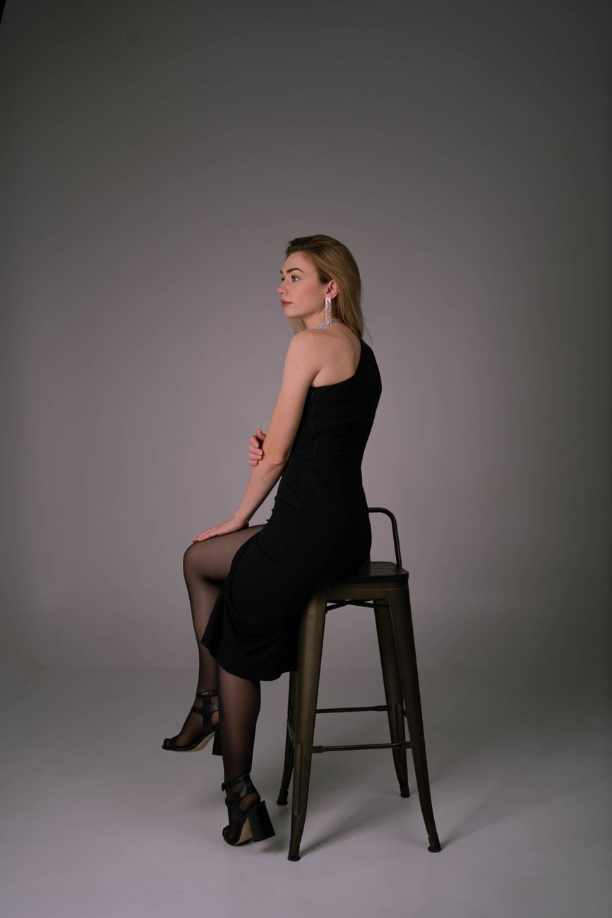 Stylish model in a black dress posing elegantly in a studio setup, Ukraine.