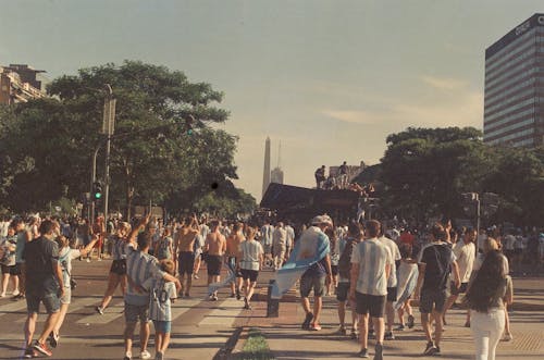 Free A Crowded City Street with People Wearing Football T-shirts Stock Photo