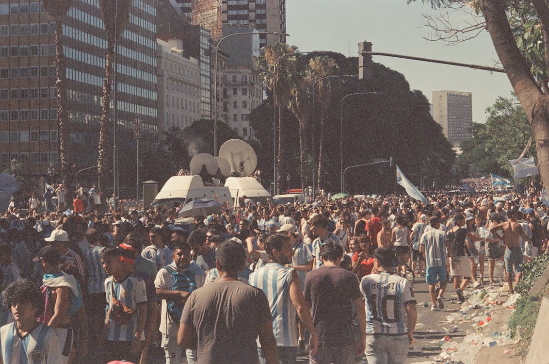 A Crowded City Street with People Wearing Football T-shirts 