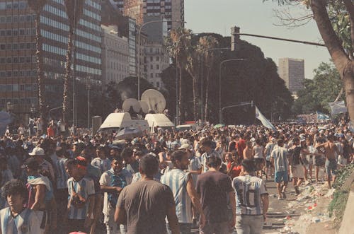 Free A Crowded City Street with People Wearing Football T-shirts  Stock Photo